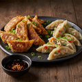 Vegetable Dumplings showing both golden pan-fried potstickers and delicate steamed dumplings with colorful vegetable filling on a dark ceramic plate with soy chili dipping sauce